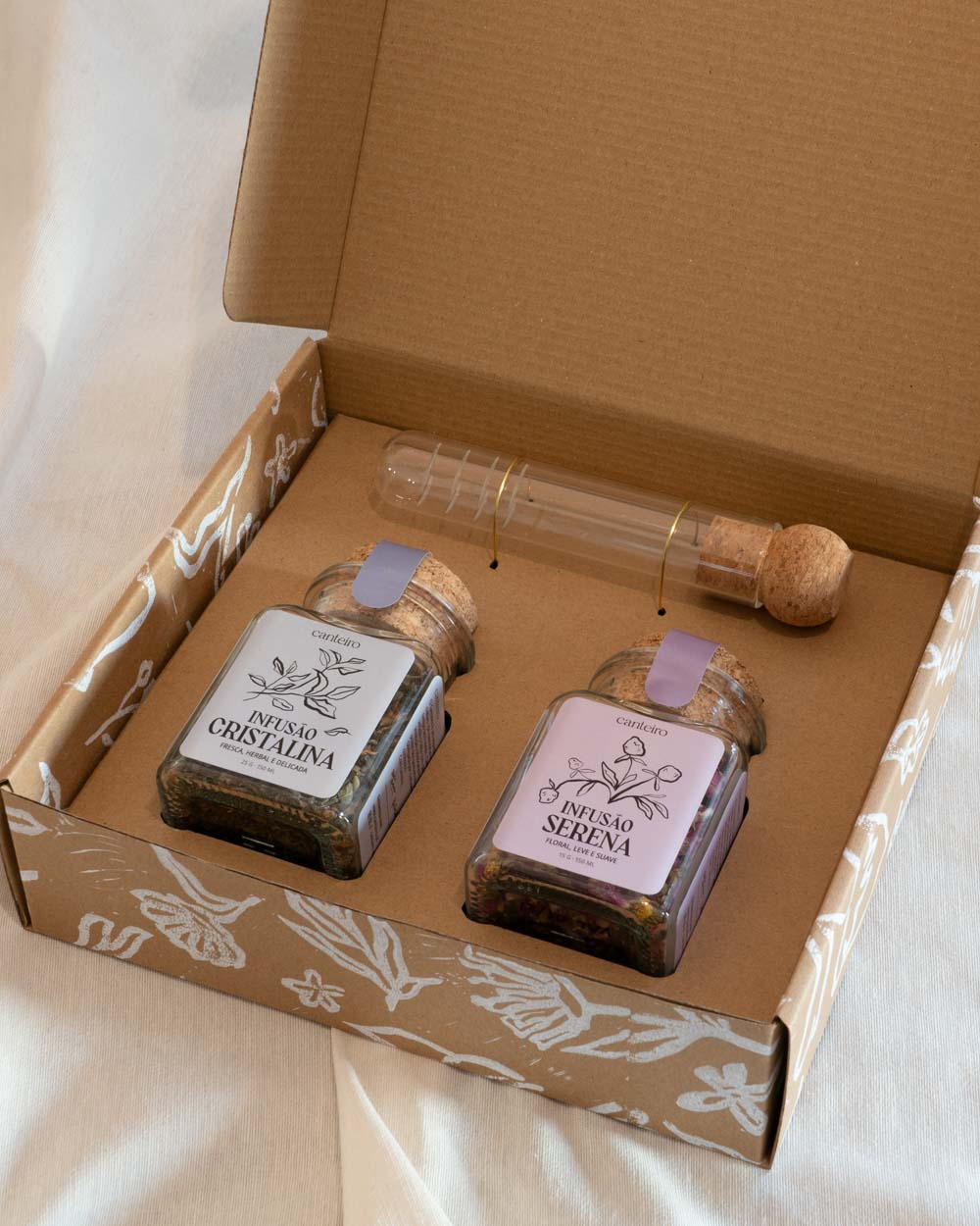Caixa com conjunto de infusões artesanais em frascos de vidro com tampa de cortiça e infusor de vidro com tampa de cortiça